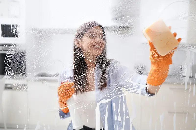 young-woman-cleaning-dirty-window-with-special-detergent