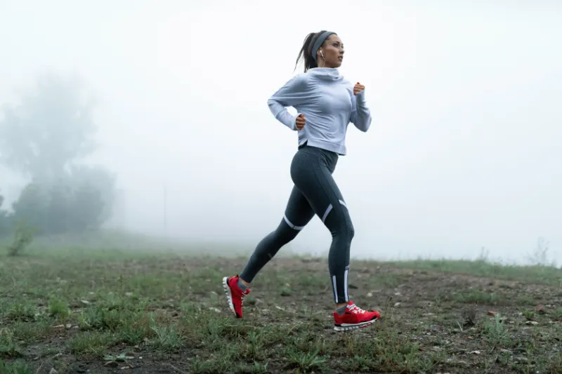 young-sportswoman-running-along-foggy-field